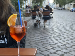 Glas mit Aperol Spritz auf einem Tisch auf der Straße