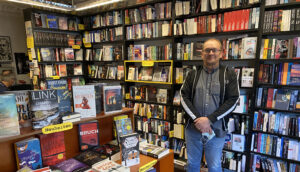 Buchhändler Christian Koch vor einer Regalwand der Buchhandlung Hammett