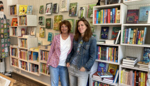 Zwei Buchhändlerinnen von einem Bücherregal