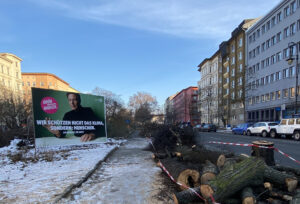 Grünstreifen mit gefällten Bäumen oberhalb des U-Bahnhofs Gneisenaustraße, links ein Wahlplakat der Grünen mit dem Slogan "Wir schützen nicht das Klima, sondern: Menschen"